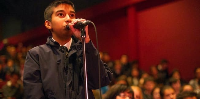 A young reader at the microphone during a youth event